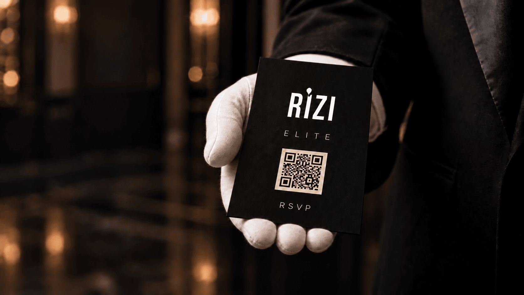 A white-gloved host holding an ivory Rizi RSVP card.